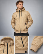 Windbreaker BBD 6100 in Beige / Black an Herrenmodel – sandbeige Nylonjacke mit Kapuze, schwarzen Reißverschlusstaschen, Kordelzug und breiten Rippbündchen