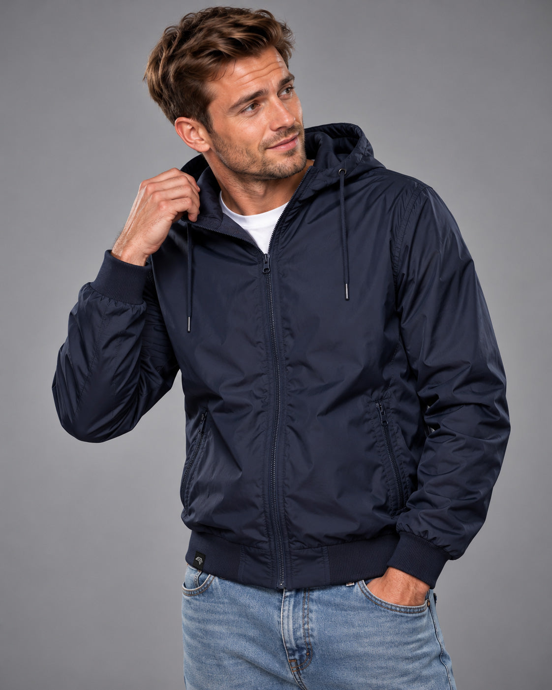 Herren-Windblouson BBD 6100 in Navy-blauen Nylon an Model im Studio, mit Mittelreißverschluss, dunklen Marineblauen Kapuzenkordeln und hüftlangem Schnitt mit breiten Bündchen.