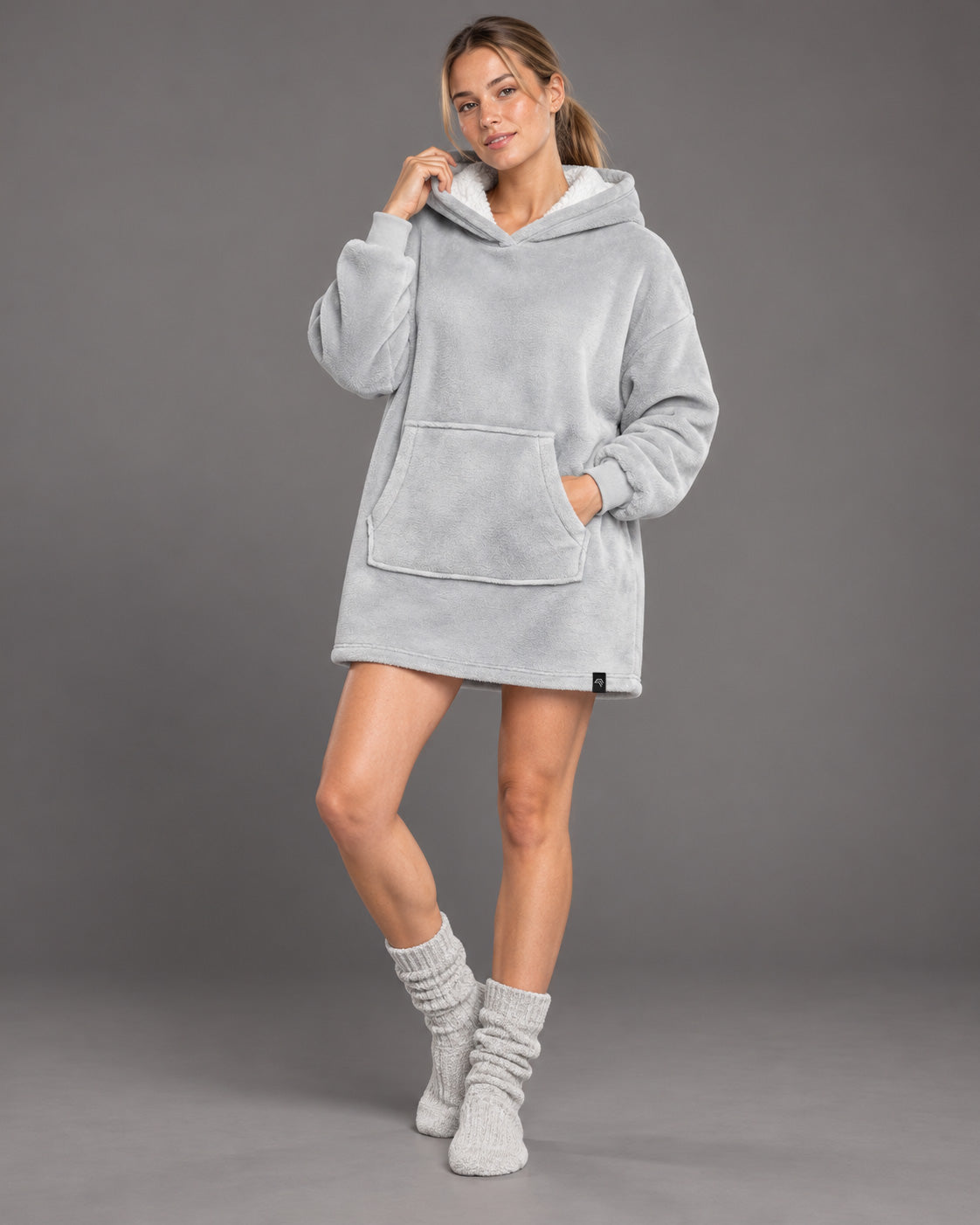 Snow Light Grau – Produktcollage des flauschigen Sherpa-Fleece-Ponchos mit Frauenmodel und Detailaufnahmen von Kapuzenöffnung, Saumnaht und Ärmelbündchen