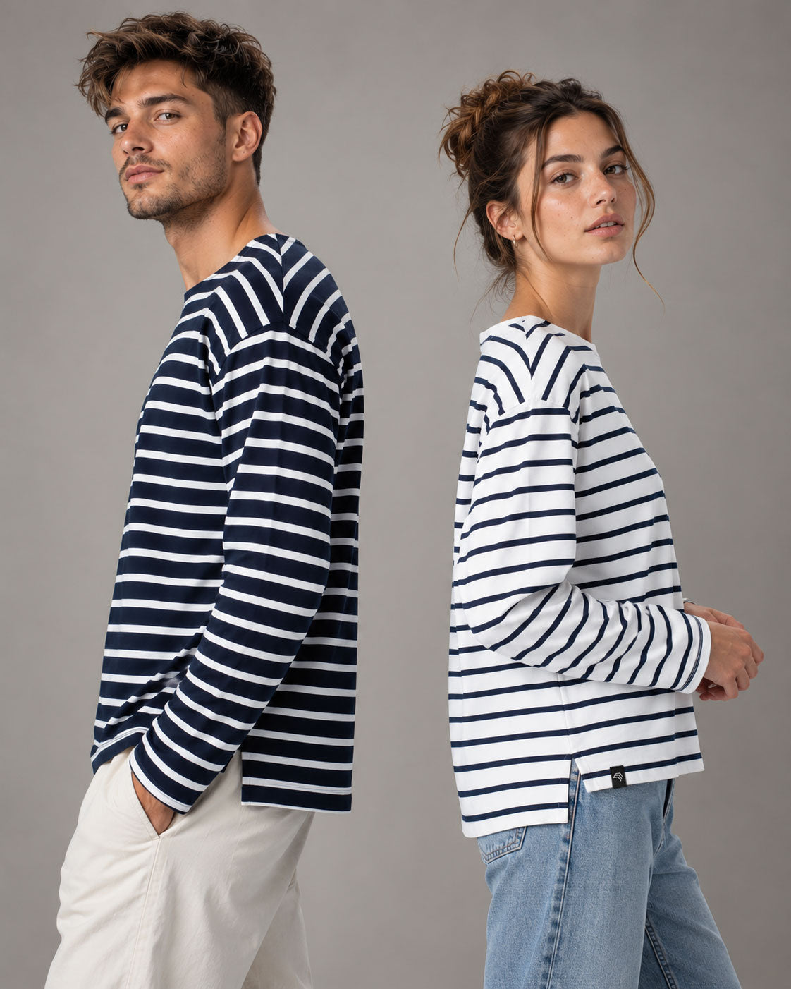 Unisex-Bretonshirt STM 6301 in Navy/Weiß am männlichen Modell und Weiß/Navy am weiblichen Modell mit langen Ärmeln, kontrastreichem Streifenmuster und lockerem, geradem Schnitt.